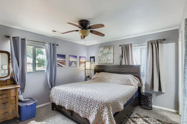 a bedroom with a bed a mirror and a window