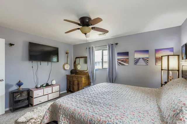 a bedroom with a bed and a flat tv screen on dresser