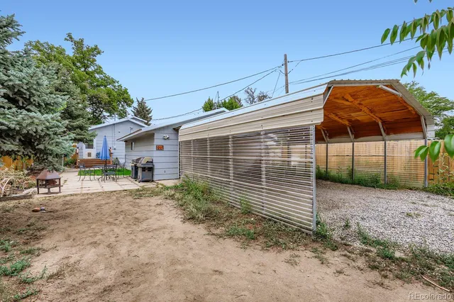 a big house with large trees and wooden fence