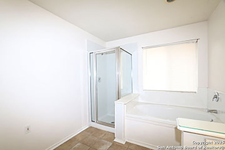 9827 Copperway Converse, TX 78109 - Photo 12 of 16 a bathroom with a bathtub and a shower