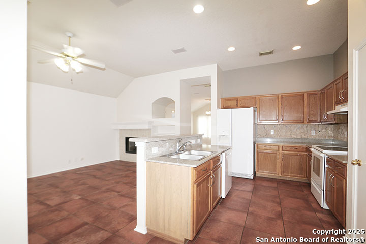 9827 Copperway Converse, TX 78109 - Photo 7 of 16 a kitchen with a sink a stove a refrigerator and cabinets