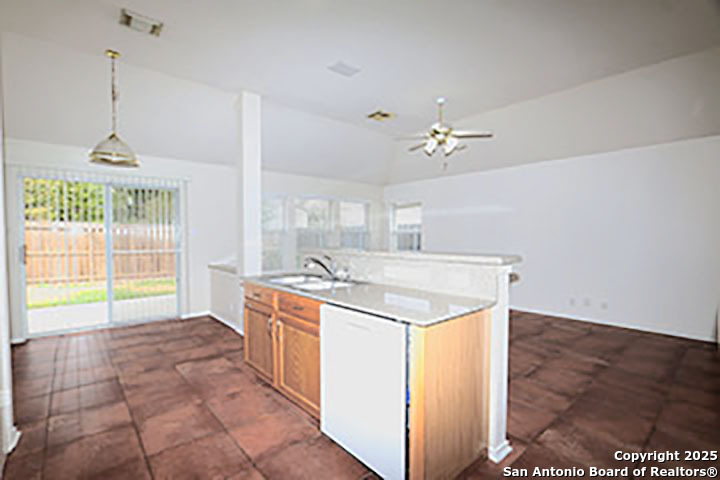 9827 Copperway Converse, TX 78109 - Photo 8 of 16 a kitchen with a stove a sink a window and a counter top space
