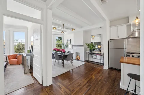 a view of a dining room with furniture a rug and wooden floor