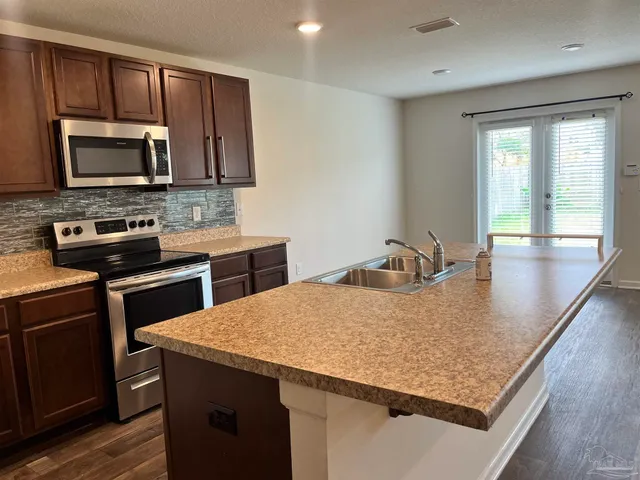 a kitchen with a stove a sink and a microwave