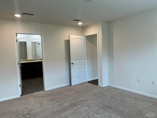 an empty room with closet and mirror