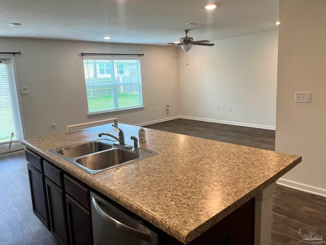 a kitchen with a sink a counter and wooden floor