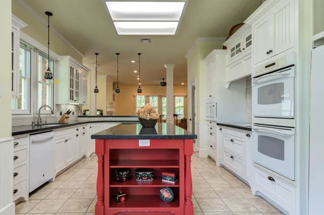 a kitchen with granite countertop white cabinets and white appliances