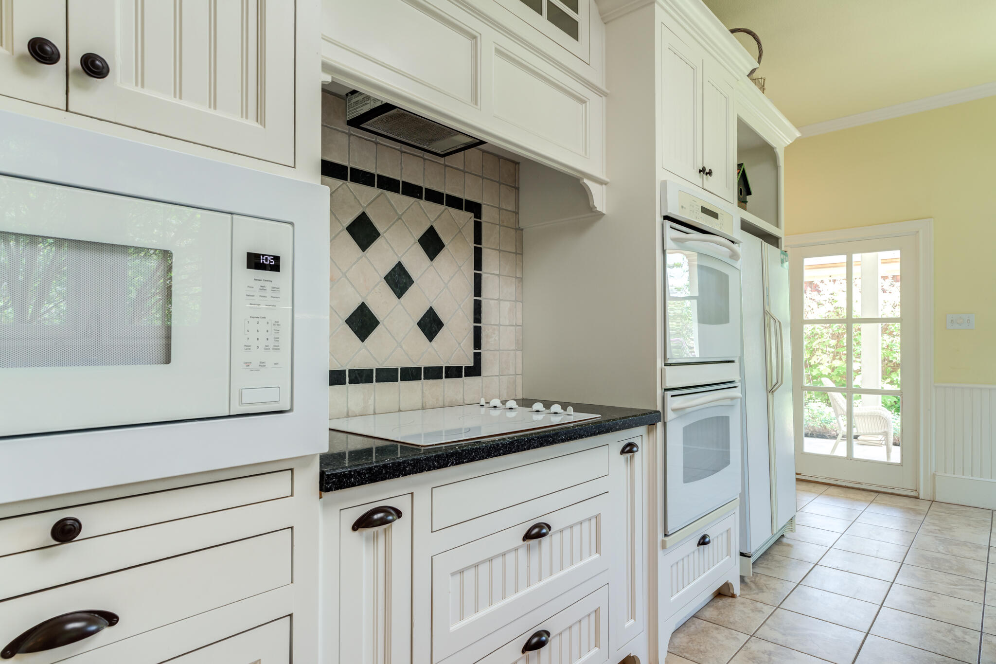 4709 116th Street Lubbock, TX 79424 - Photo 29 of 58 a kitchen with granite countertop white cabinets and white appliances