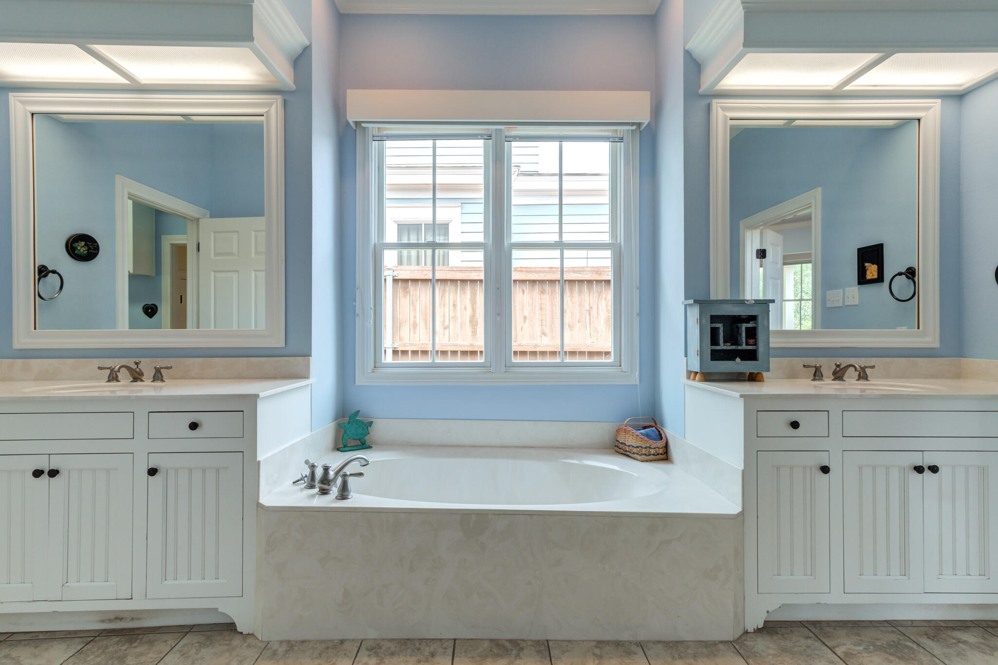 4709 116th Street Lubbock, TX 79424 - Photo 37 of 58 a bathroom with a bathtub a sink a mirror and a window