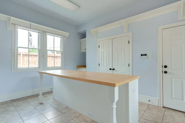 an empty room with wooden floor chandelier fan and windows