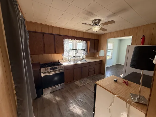 a kitchen with a refrigerator a sink dishwasher a stove and a refrigerator with wooden floor