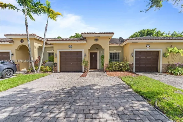 a front view of a house with a yard and a garage