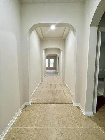 a view of a hallway with wooden floor and a mirror