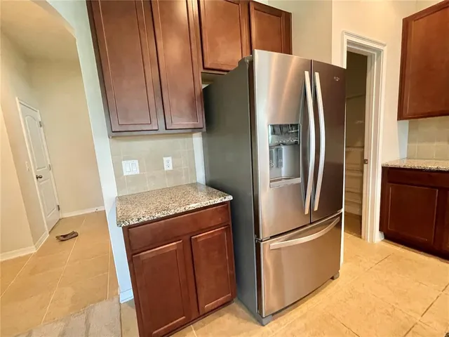 a metallic refrigerator freezer sitting in a kitchen