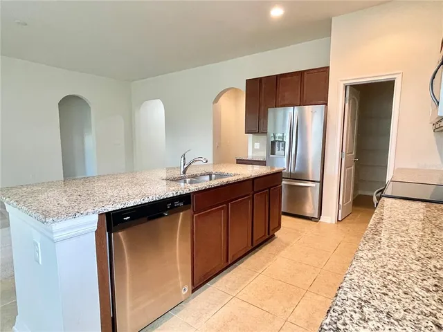 a kitchen with stainless steel appliances granite countertop a sink stove and refrigerator