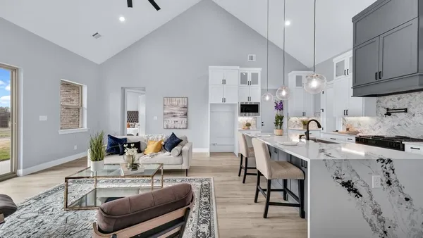 a living room with furniture kitchen island a sink and a stove