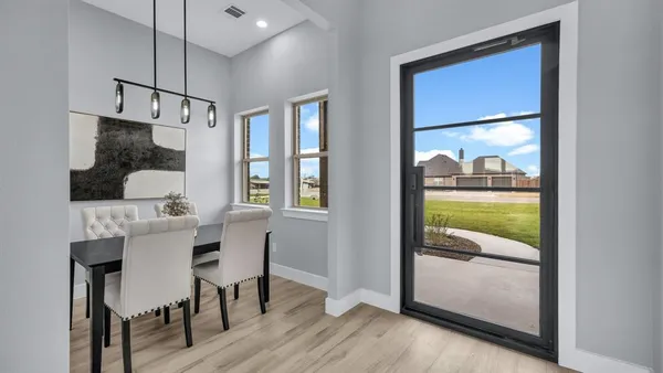 a dining room with furniture and a floor to ceiling window