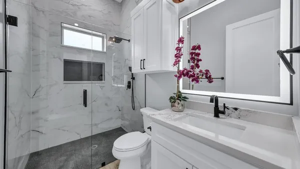 a bathroom with a sink a toilet and shower