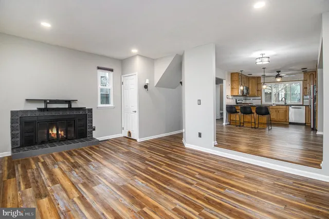 a view of a livingroom with wooden floor and a fireplace