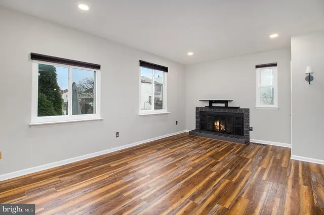 a view of empty room with wooden floor and fireplace
