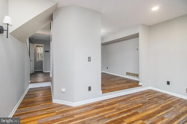 a view of a hallway with wooden floor and staircase