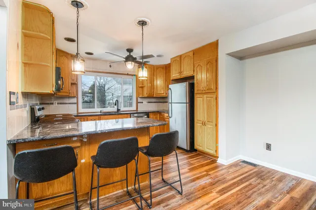 a kitchen with stainless steel appliances granite countertop a sink and a refrigerator