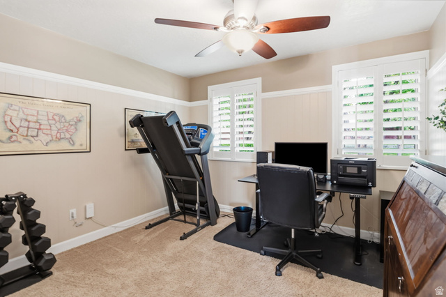 1101 Old Dairy Road Sandy, UT 84094 - Photo 17 of 36 Split level Room/ Office featuring neutral wall tones with white wainscoting and trim, two windows with white plantation shutters, a ceiling fan with wood-finish blades, and carpet flooring