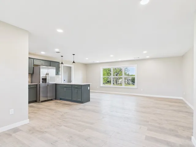 a view of kitchen with kitchen island a sink stainless steel appliances and cabinets