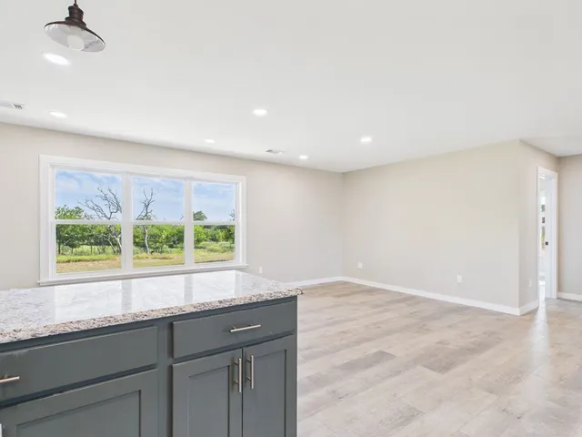 an empty room with a window and a ceiling fan