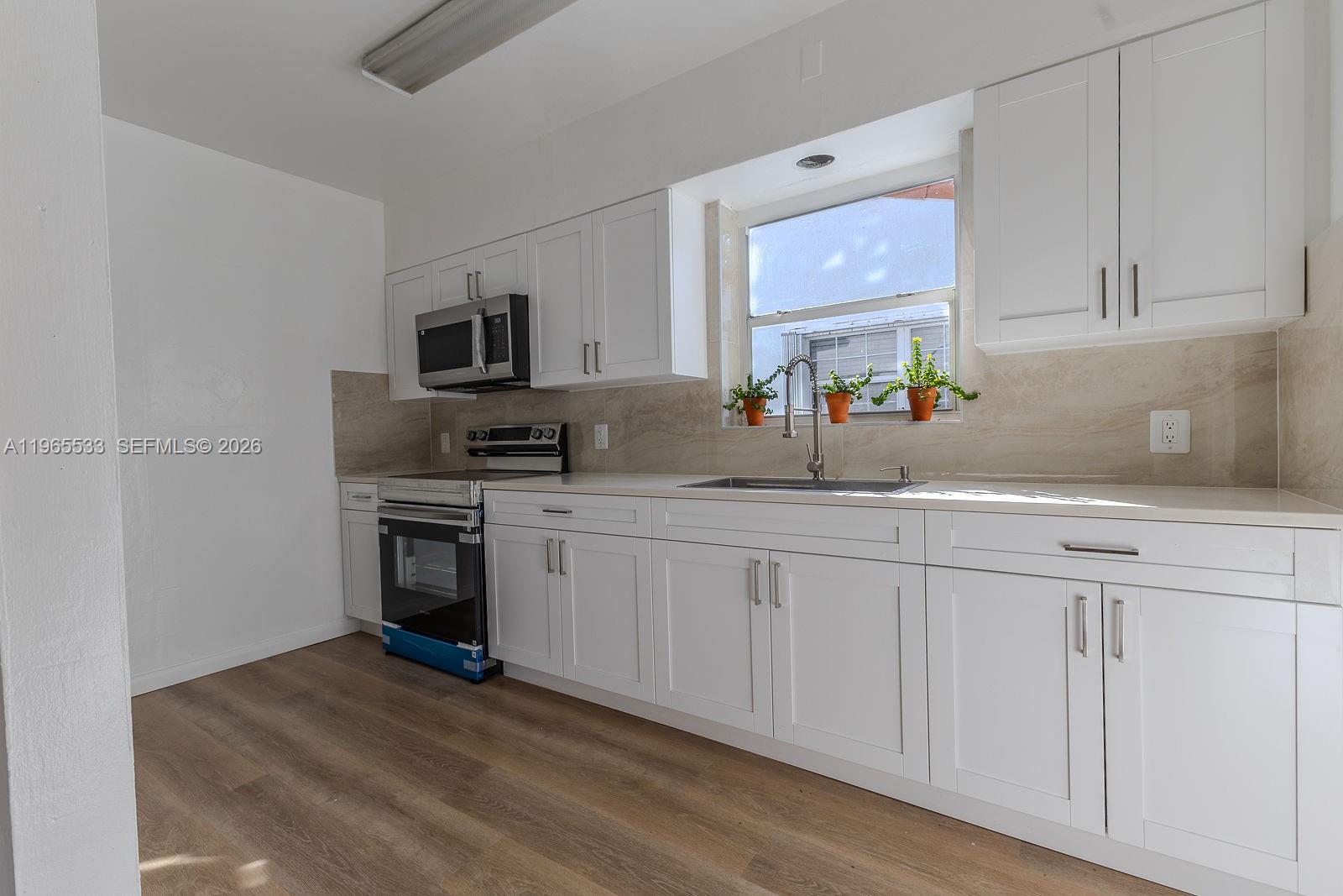 1441 Southwest 17th Street Miami, FL 33145 - Photo 12 of 26 a kitchen with granite countertop a sink cabinets and stainless steel appliances