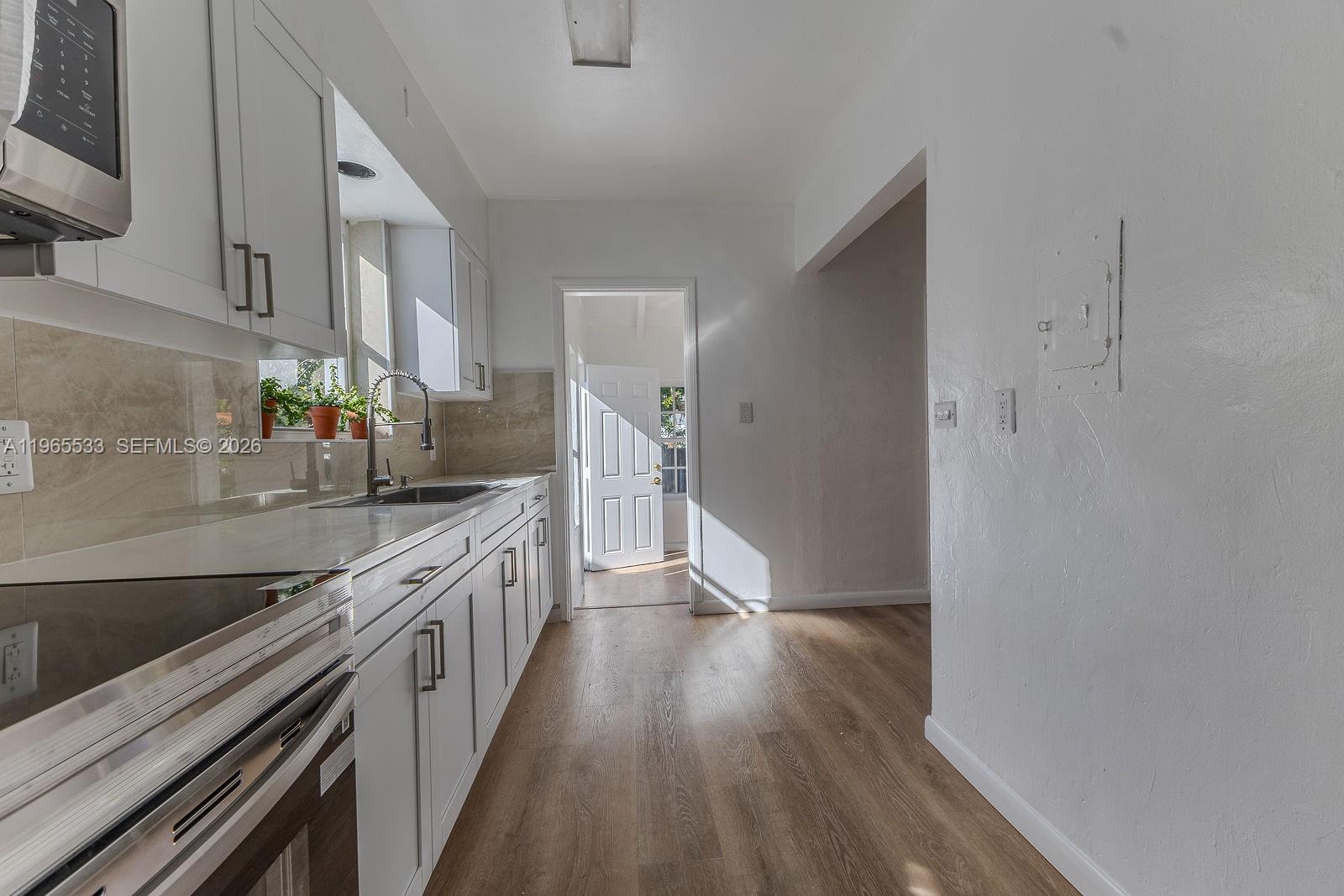 1441 Southwest 17th Street Miami, FL 33145 - Photo 14 of 26 a kitchen with stainless steel appliances a sink and wooden floor