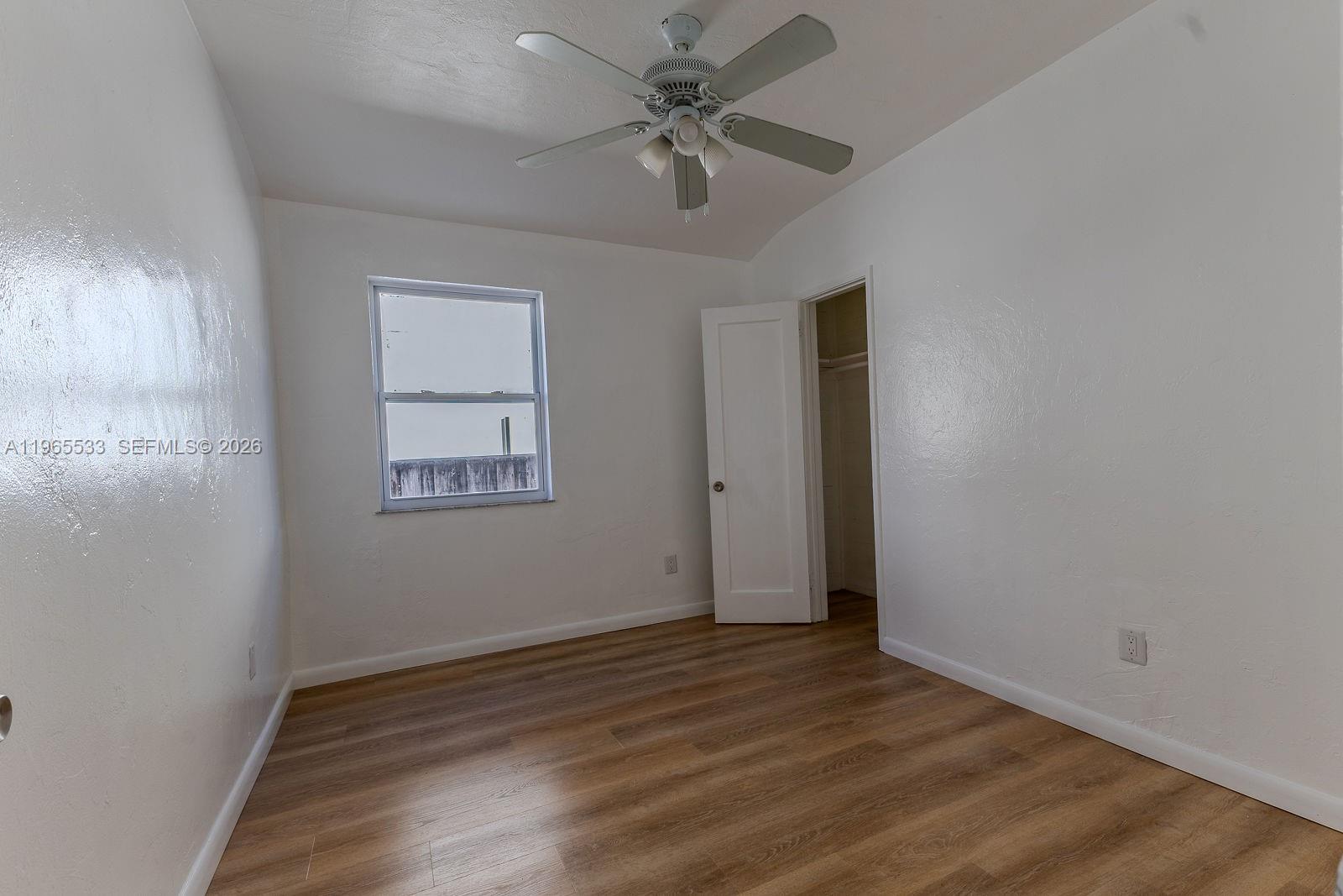1441 Southwest 17th Street Miami, FL 33145 - Photo 19 of 26 an empty room with wooden floor ceiling fan and windows
