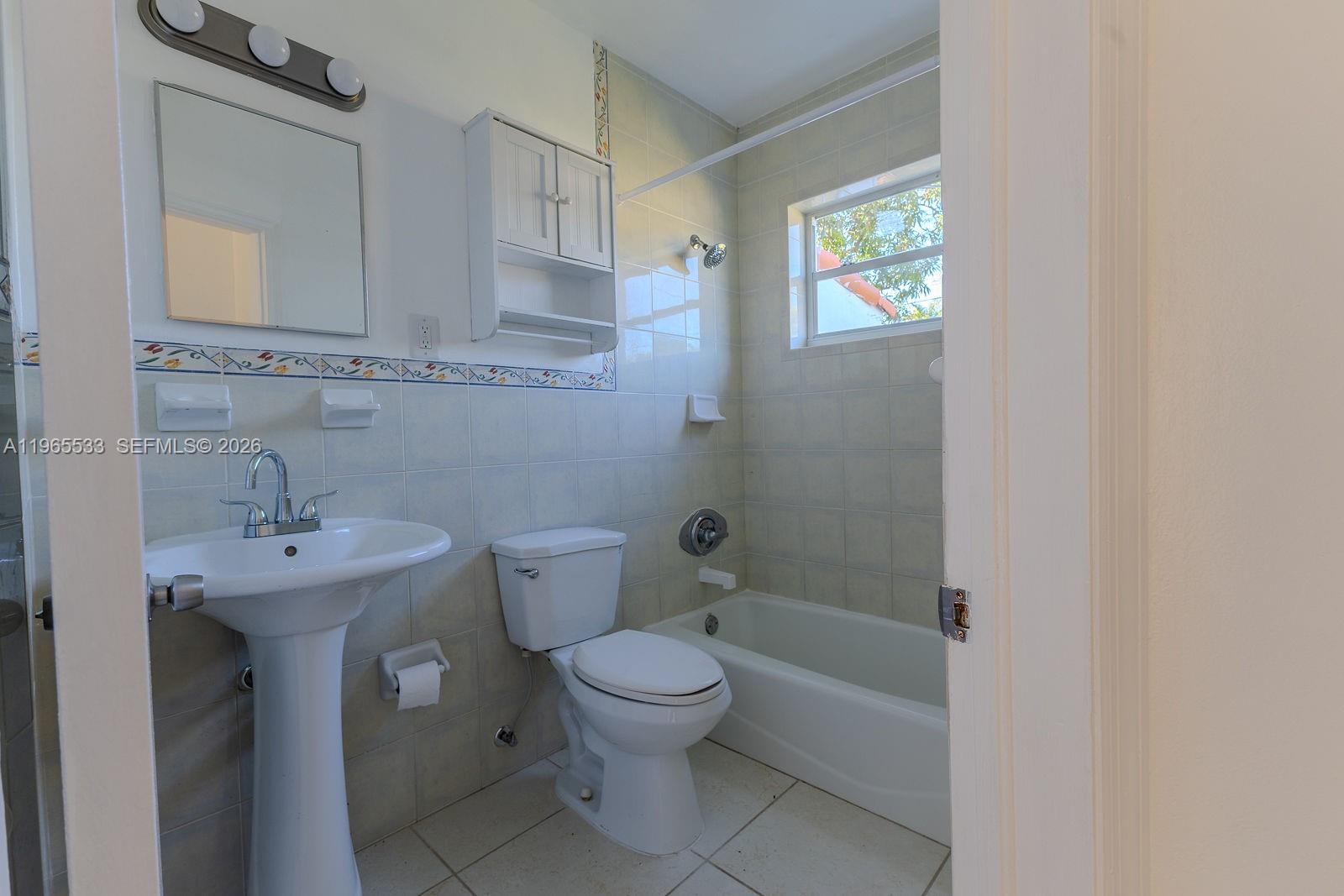 1441 Southwest 17th Street Miami, FL 33145 - Photo 22 of 26 a bathroom with a toilet a sink and mirror