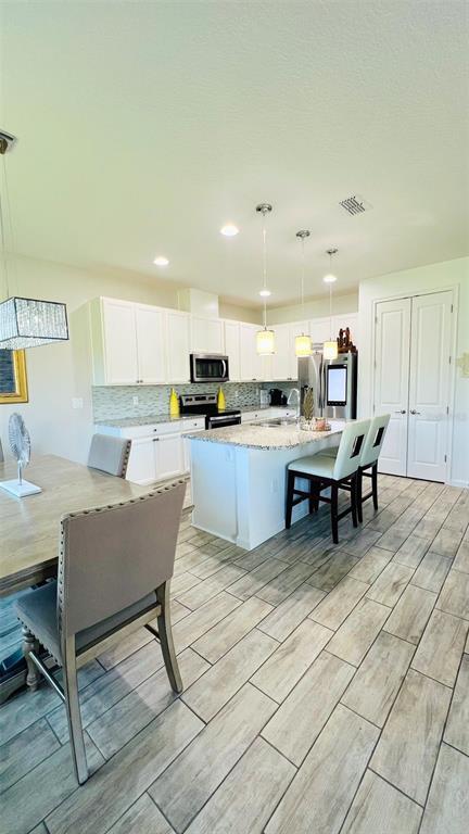 1257 Castlevecchio Loop Orlando, FL 32825 - Photo 6 of 12 a view of a kitchen with a dining table chairs and a refrigerator