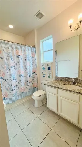 a spacious bathroom with a granite countertop sink a toilet and a shower