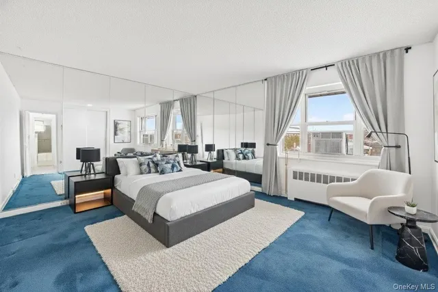 a spacious bedroom with a bed couch and windows