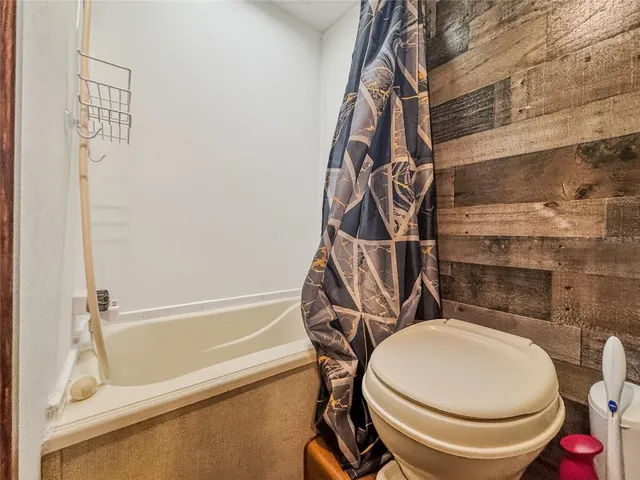 a bathroom with a toilet and a shower