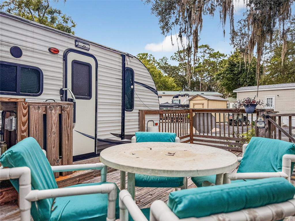 25184 Northeast 143rd Place Salt Springs, FL 32134 - Photo 23 of 42 a view of a patio with table and chairs with wooden floor and fence