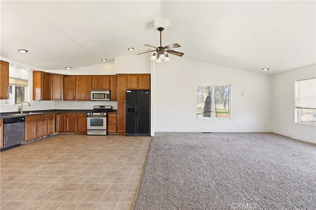 a view of kitchen with stainless steel appliances granite countertop a stove and a refrigerator