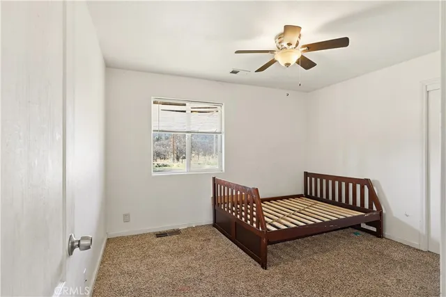 a view of wooden floor and a ceiling fan in a room