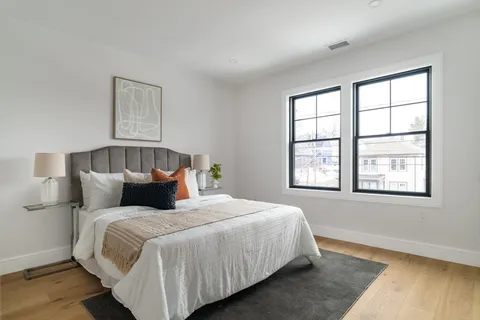 a bedroom with a bed and wooden floor