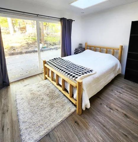 a bedroom with a bed and wooden floor