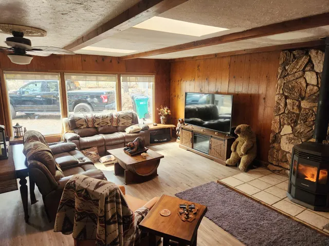a living room with furniture a flat screen tv and a floor to ceiling window