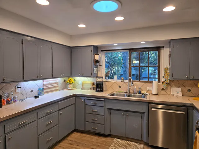 a kitchen with a sink a window and cabinets