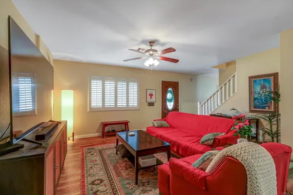 a living room with furniture a flat screen tv and a window