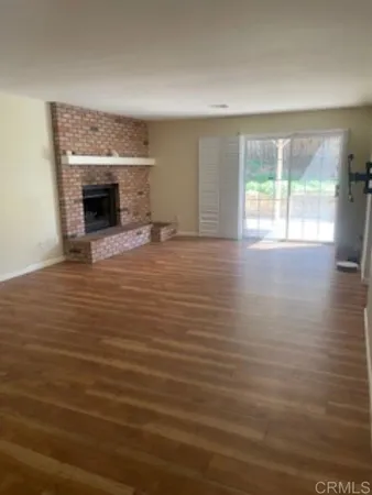 an empty room with windows and fireplace