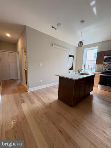 a kitchen with kitchen island a sink and wooden floor