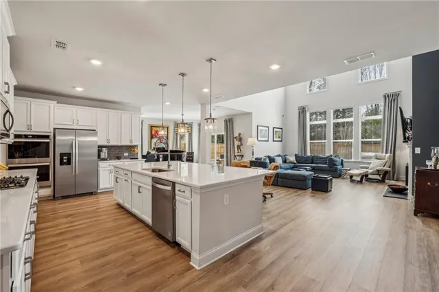 a large kitchen with stainless steel appliances and wooden cabinets