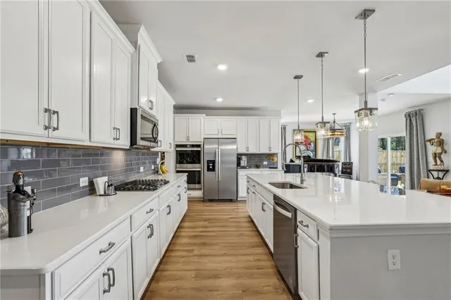 a large white kitchen with kitchen island a stove a sink a center island and furniture