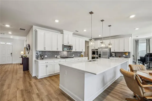 a kitchen with stainless steel appliances kitchen island granite countertop a sink and cabinets